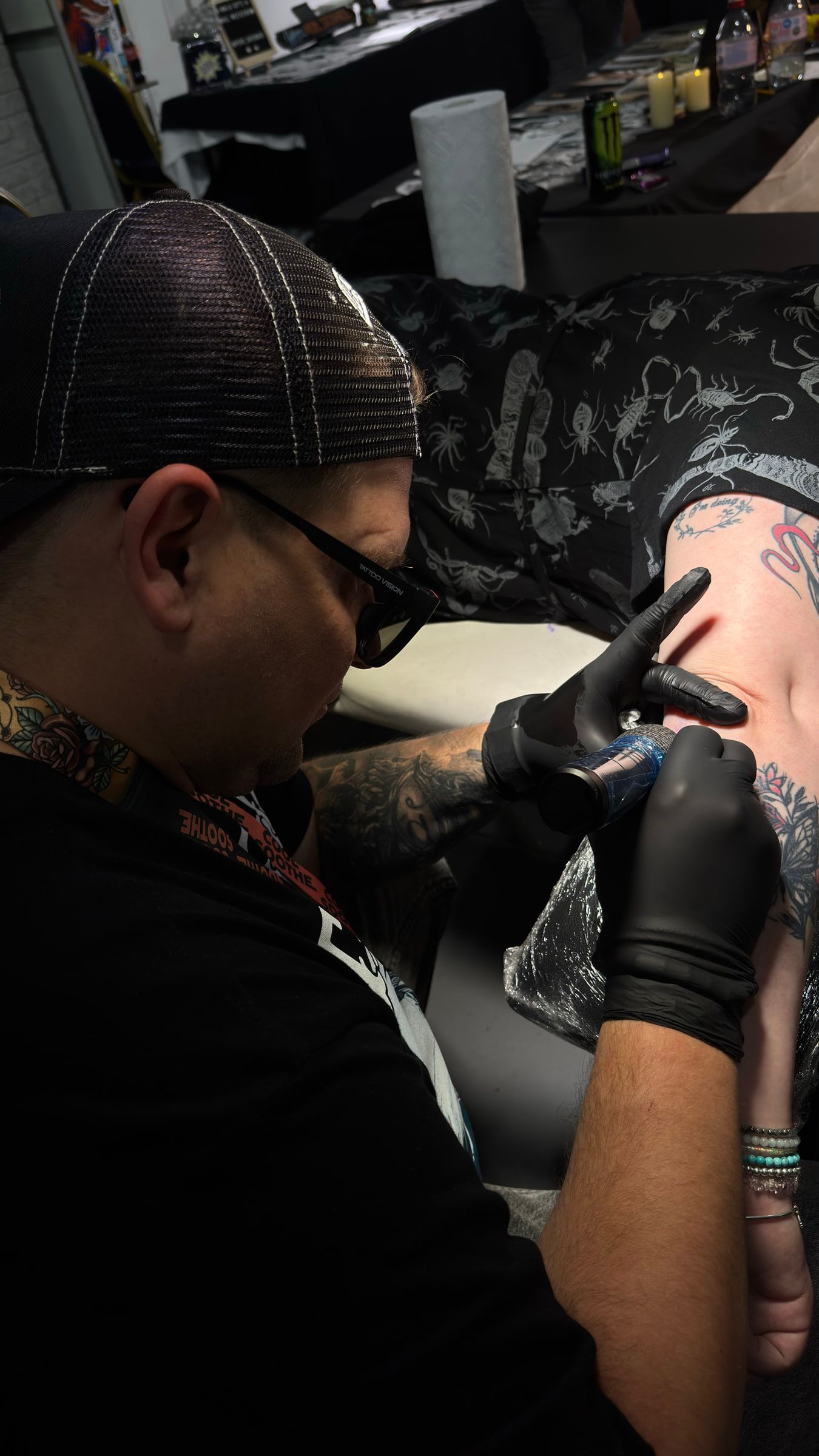 Sigis Ka tattooing a client's arm at the studio.